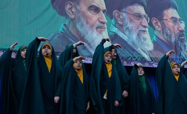 Girls sing a song as they show the movement of missiles with their hands next to the portraits of the late Iranian revolutionary founder Ayatollah Khomeini, left, late Supreme Leader Ayatollah Ali Khamenei, center, and Supreme Leader Ayatollah Mojtaba Khamenei, in a state-organised rally celebrating the birthday of Imam Reza, the 8th Shiite Muslims' Imam, and supporting the supreme leader, in Tehran, Iran, Wednesday, April 29, 2026. (AP Photo/Vahid Salemi)