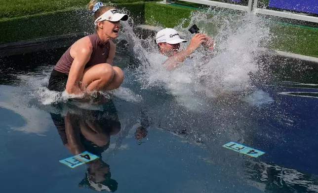 Nelly Korda jumps in the water with her caddie after winning the Chevron Championship LPGA golf tournament Sunday, April 26, 2026, in Houston. (AP Photo/Ashley Landis)