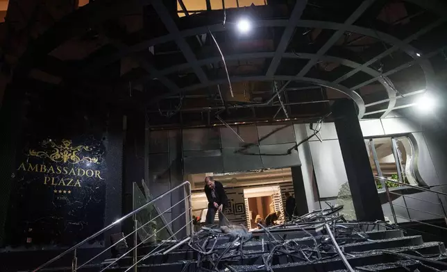 A man clear the rubble of a hotel damaged after a Russian strike on residential area in Kyiv, Ukraine, on Thursday, April 16, 2026. (AP Photo/Evgeniy Maloletka)