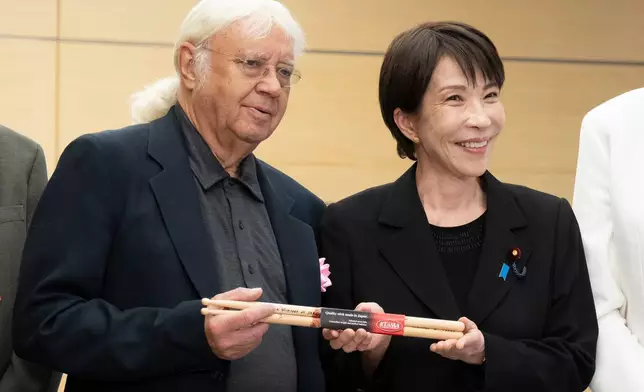 Japan's Prime Minister Sanae Takaichi, right, poses with Ian Paice, a member of British rock band Deep Purple during their meeting at the Prime Minister's Office in Tokyo, Friday, April 10, 2026. (Yuichi Yamazaki/Pool Photo via AP)