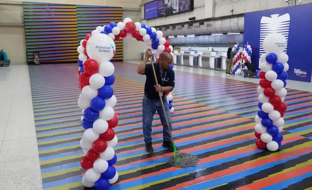 A worker cleans the check-in area ahead of the arrival of a U.S. commercial flight at Simon Bolivar International Airport in Maiquetia, Venezuela, Thursday, April 30, 2026, as direct air service between the United States and Venezuela resumes after seven years. (AP Photo/Ariana Cubillo)
