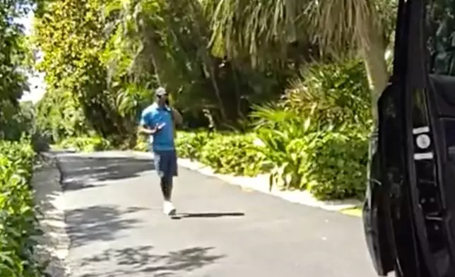 In this image from police body camera video released by the Martin County, Fla., Sheriff's Office, golfer Tiger Woods speaks on his cellphone following a car crash in Jupiter Island, Fla., Friday, March 27, 2026. (Martin County Sheriff's Office via AP)