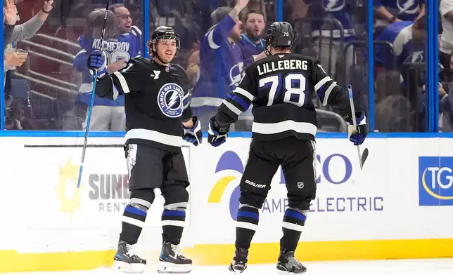 Tampa Bay Lightning defenseman Charle-Edouard D'Astous (51) celebrates his goal against the Boston Bruins with defenseman Emil Lilleberg (78) during the third period of an NHL hockey game Saturday, April 4, 2026, in Tampa, Fla. (AP Photo/Chris O'Meara)