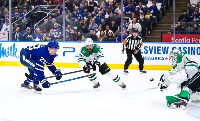 Toronto Maple Leafs left wing Matthew Knies (23) tries to shoot on net against Dallas Stars defenseman Ilya Lyubushkin (46) and goalie Casey DeSmith (1) during second-period NHL hockey game action in Toronto, Monday, April 13, 2026. (Cole Burston/The Canadian Press via AP)