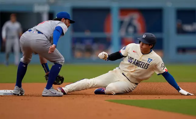 Los Angeles Dodgers' Shohei Ohtani, right, steals second as Chicago Cubs shortstop Dansby Swanson waits without the ball during the first inning of a baseball game Saturday, April 25, 2026, in Los Angeles. (AP Photo/Mark J. Terrill)