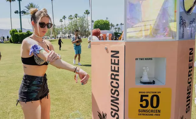 FILE - A festivalgoer applies sunscreen at the Coachella Valley Music and Arts Festival in Indio, Calif., on April 19, 2024. (Photo by Amy Harris/Invision/AP, File)