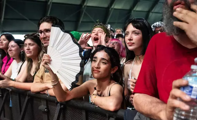 FILE - A festivalgoer holds a fan at the Coachella Valley Music and Arts Festival in Indio, Calif., on April 11, 2025. (Photo by Amy Harris/Invision/AP, File)