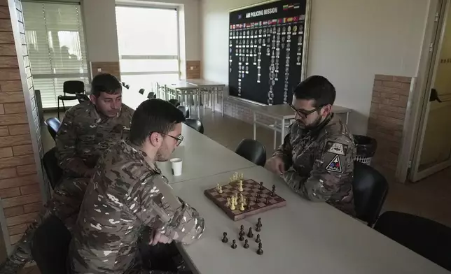 Members of a French air force detachment of personnel and Rafale jets stationed on a monthslong deployment at the Siauliai Air Base in Lithuania on a NATO air-policing mission play chess in the detachment's headquarters at the base on Monday, April 20, 2026. (AP Photo/John Leicester)