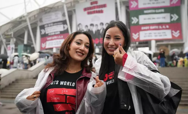 Fans of K-pop band BTS pose for a photo outside the venue for the BTS World Tour Arirang in Goyang, South Korea, Thursday, April 9, 2026. (AP Photo/Lee Jin-man)