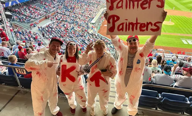 Philadelphia Phillies fans that call themselves "Painter's Painters" pose for a photo as they cheer on rookie Phillies pitcher Andrew Painter during his MLB debut in a baseball game against the Washington Nationals, Tuesday, March 31, 2026, in Philadelphia. (AP Photo/Dan Gelston)
