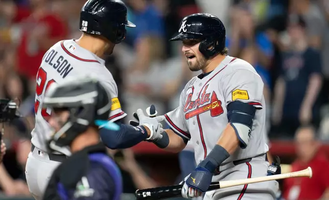 Atlanta Braves third baseman Austin Riley (27) celebrates a home run by Atlanta Braves first baseman Matt Olson (28) during the ninth inning of a baseball game against the Arizona Diamondbacks, Friday, April 3, 2026, in Phoenix. (AP Photo/Rebecca Noble)