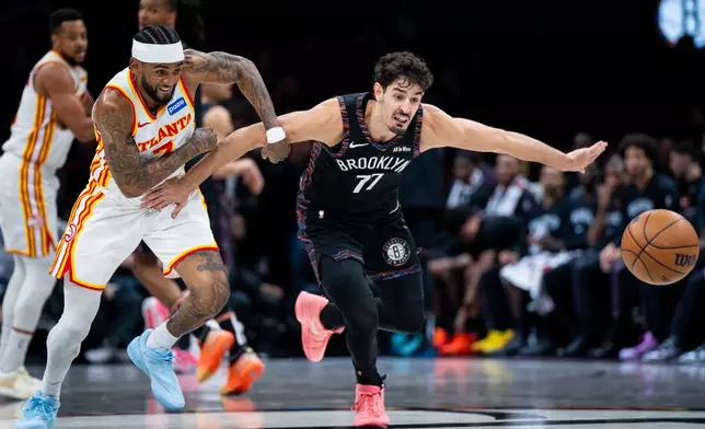 Atlanta Hawks guard Nickeil Alexander-Walker (7) and Brooklyn Nets guard Ben Saraf (77) race for the ball during the first half of an NBA basketball game, Friday, April 3, 2026, in New York. (AP Photo/Angelina Katsanis)