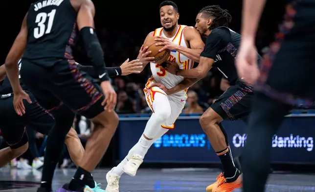 Atlanta Hawks guard CJ McCollum (3) fights through the Brooklyn Nets' defense during the first half of an NBA basketball game, Friday, April 3, 2026, in New York. (AP Photo/Angelina Katsanis)