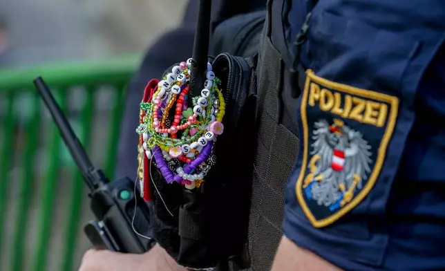 FILE - A police officer is decorated with Taylor Swift bracelets while guarding the city center in Vienna on Aug. 8, 2024. (AP Photo/Heinz-Peter Bader, File)