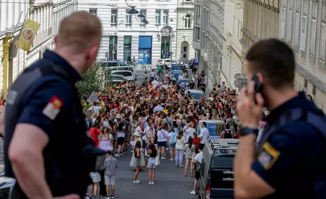 FILE - Austrian police officers watch a gathering of Taylor Swift fans in the city centre in Vienna on Aug. 8, 2024. (AP Photo/Heinz-Peter Bader, File)