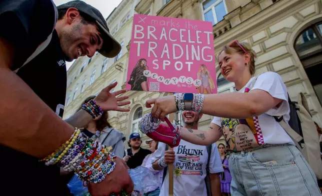 FILE - Fans of Taylor Swift also known as Swifties trade bracelets in the city centre in Vienna, Aug. 8, 2024. (AP Photo/Heinz-Peter Bader, File)