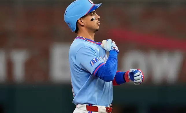 Atlanta Braves' Mauricio Dubón (14) celebrates his RBI-double against the Cleveland Guardians in the second inning of a baseball game, Sunday, April 12, 2026, in Atlanta. (AP Photo/Mike Stewart)