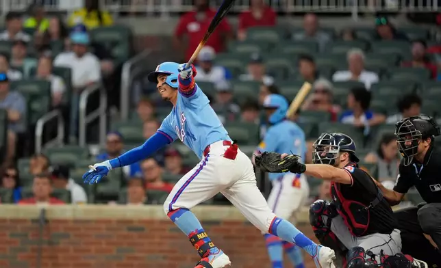 Atlanta Braves' Mauricio Dubón (14) hits an RBI-double against the Cleveland Guardians int her second inning of a baseball game, Sunday, April 12, 2026, in Atlanta. (AP Photo/Mike Stewart)