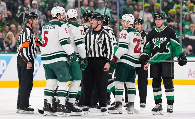 Minnesota Wild and Dallas Stars players are separated by officials after scuffles broke out following an injury to the Wild's Yakov Trenin in the first period of Game 2 of a first-round NHL Stanley Cup playoffs hockey series Monday, April 20, 2026, in Dallas. (AP Photo/Tony Gutierrez)un