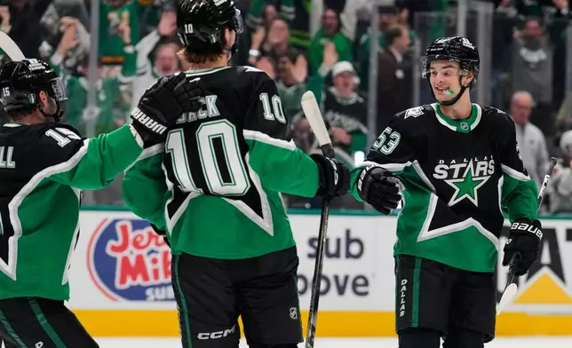 Dallas Stars' Colin Blackwell (15), Oskar Bäck (10) and Wyatt Johnston (53) celebratee Johnston's goal in the first period of Game 2 of a first-round NHL Stanley Cup playoffs hockey series against the Minnesota Wild Monday, April 20, 2026, in Dallas. (AP Photo/Tony Gutierrez)un