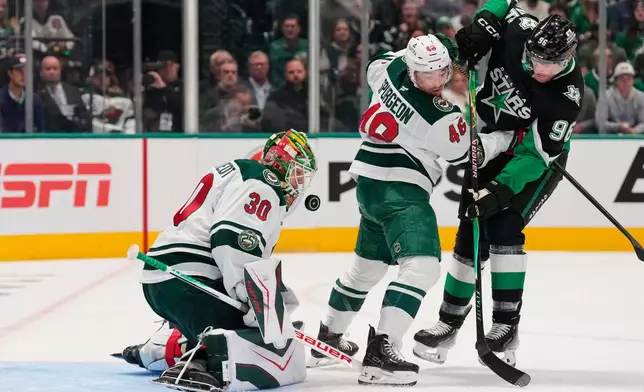 Minnesota Wild goaltender Jesper Wallstedt (30) defends against a shot from Dallas Stars' Mikko Rantanen (96) as Jared Spurgeon (46) helps defend in the first period of Game 2 of a first-round NHL Stanley Cup playoffs hockey series Monday, April 20, 2026, in Dallas. (AP Photo/Tony Gutierrez)un