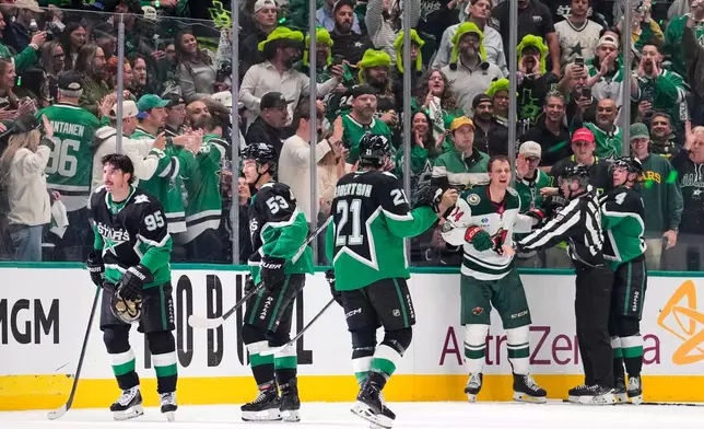 Dallas Stars' Matt Duchene (95) and Wyatt Johnston (53) skate to the bench after Duchene scored as officials hold Minnesota Wild's Joel Eriksson Ek (14) after a fight broke out following the score in the second period of Game 2 of a first-round NHL Stanley Cup playoffs hockey series Monday, April 20, 2026, in Dallas. (AP Photo/Tony Gutierrez)un
