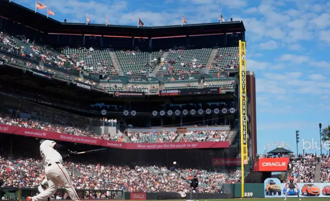 San Francisco Giants' Rafael Devers hits an RBI single against the Philadelphia Phillies during the eighth inning of a baseball game in San Francisco, Wednesday, April 8, 2026. (AP Photo/Jeff Chiu)