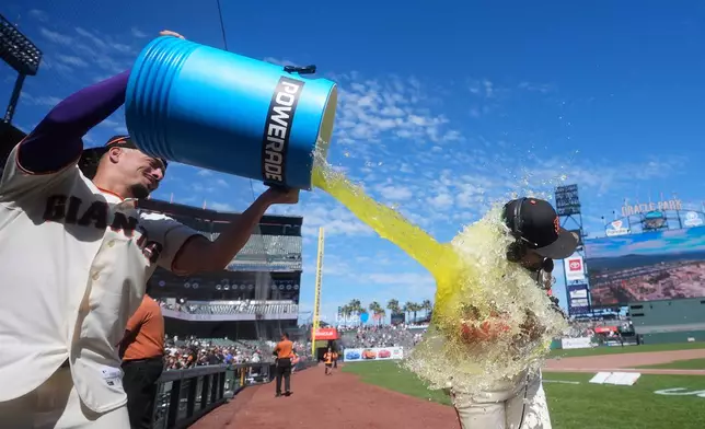 San Francisco Giants' Luis Arraez, right, is doused by Willy Adames after a baseball game against the Philadelphia Phillies in San Francisco, Wednesday, April 8, 2026. (AP Photo/Jeff Chiu)