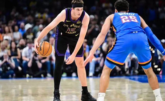 Los Angeles Lakers guard Austin Reaves (15) drives against Oklahoma City Thunder guard Ajay Mitchell (25) during the first half of an NBA basketball game Thursday, April. 2, 2026, in Oklahoma City. (AP Photo/Gerald Leong)