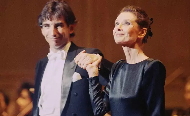 FILE - Audrey Hepburn, right, appears with New World Symphony's artistic advisor Michael Tilson Thomas at the Academy of Music in Philadelphia on March 19, 1990. (AP Photo/Bill Cramer, File)