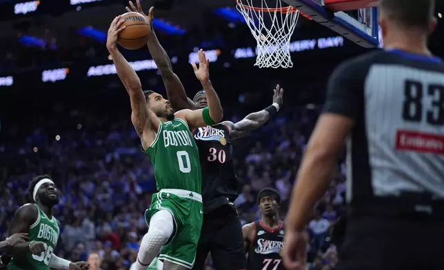 Boston Celtics' Jayson Tatum, left, goes up for a shot against Philadelphia 76ers' Adem Bona during the first half of Game 3 in a first-round NBA playoffs basketball series Friday, April 24, 2026, in Philadelphia. (AP Photo/Matt Slocum)