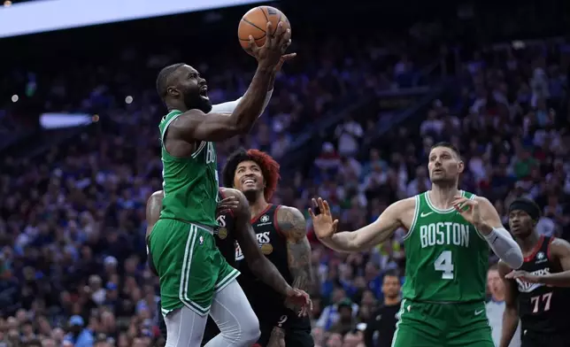 Boston Celtics' Jaylen Brown, left, goes up for a shot past Philadelphia 76ers' Kelly Oubre Jr. during the first half of Game 3 in a first-round NBA playoffs basketball series Friday, April 24, 2026, in Philadelphia. (AP Photo/Matt Slocum)