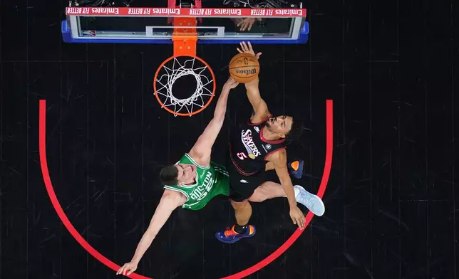 Philadelphia 76ers' Quentin Grimes, right, goes up for a shot against Boston Celtics' Luka Garza during the first half of Game 3 in a first-round NBA playoffs basketball series Friday, April 24, 2026, in Philadelphia. (AP Photo/Matt Slocum)