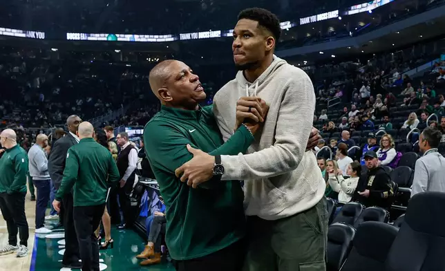 Milwaukee Bucks head coach Doc Rivers, center left, and Giannis Antetokounmpo, center right, embrace before an NBA basketball game against the Brooklyn Nets, Friday, April 10, 2026, in Milwaukee. (AP Photo/Jeffrey Phelps)