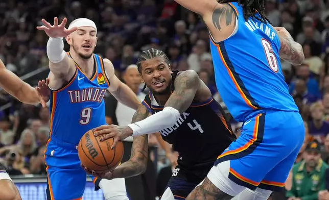 Phoenix Suns guard Jalen Green (4) tries to drive to the basket between Oklahoma City Thunder guard Alex Caruso (9) and Thunder forward Jaylin Williams (6) during the first half of Game 3 of a first-round NBA playoffs basketball series, Saturday, April 25, 2026, in Phoenix. (AP Photo/Ross D. Franklin)