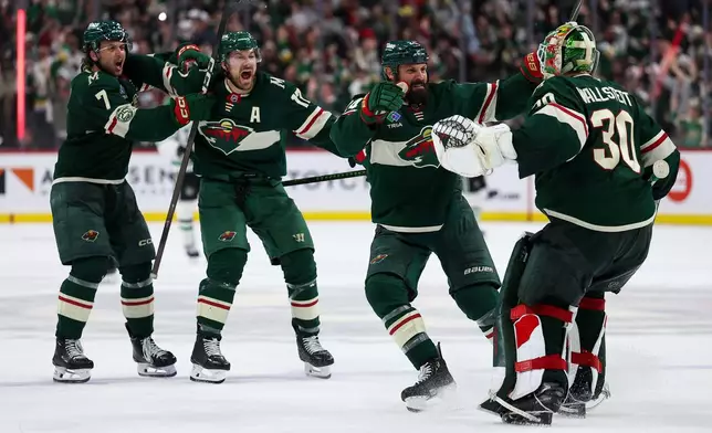 Minnesota Wild players celebrate after their team's win over the Dallas Stars during overtime of Game 4 in the first round of the NHL Stanley Cup hockey playoffs Saturday, April 25, 2026, in St. Paul, Minn. (AP Photo/Matt Krohn)
