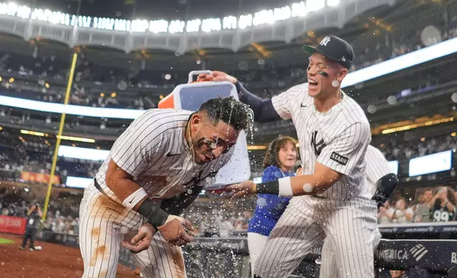 New York Yankees' Aaron Judge, right, celebrates with José Caballero after Caballero had a walk-off two run hit during the ninth inning of a baseball game against the Los Angeles Angels Wednesday, April 15, 2026, in New York. (AP Photo/Frank Franklin II)