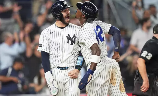 New York Yankees' Austin Wells, left, celebrates with Jazz Chisholm Jr. after they scored on a walk-off two run hit during the ninth inning of a baseball game against the Los Angeles Angels Wednesday, April 15, 2026, in New York. (AP Photo/Frank Franklin II)