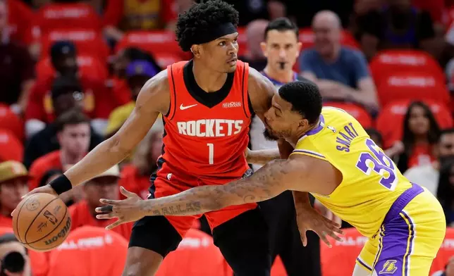 Houston Rockets guard Amen Thompson (1) looks to drive around Los Angeles Lakers guard Marcus Smart (36) who reaches in during the first half of Game 3 in a first-round NBA playoffs basketball series Friday April 24, 2026, in Houston. (AP Photo/Michael Wyke)