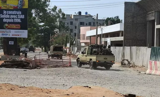 FILE - Soldiers ride in a military vehicle along a street amid an attempted coup, in Cotonou, Benin, Dec. 6, 2025. (AP Photo, File)