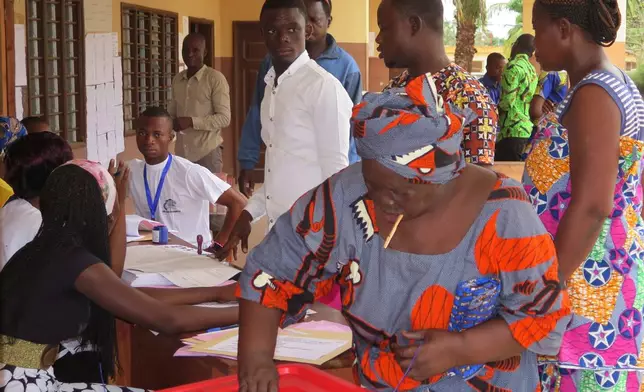 FILE - A woman casts her vote at a polling station during an election, in Seme Podji, Benin, March 6, 2016. (AP Photo/Virgile Ahissou, File)