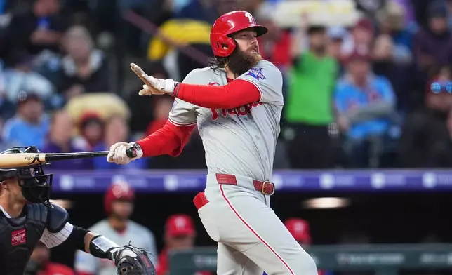 Philadelphia Phillies' Brandon Marsh singles off Colorado Rockies relief pitcher Chase Dollander in the fifth inning of a baseball game Saturday, April 4, 2026, in Denver. (AP Photo/David Zalubowski)