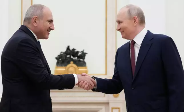Russian President Vladimir Putin, right, and Armenian Prime Minister Nikol Pashinyan greet each other during their meeting at the Kremlin in Moscow, Russia, Wednesday, April 1, 2026. (AP Photo/Pavel Bednyakov, Pool)