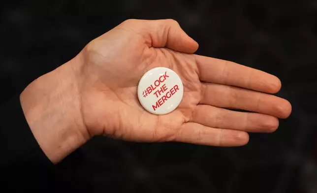 A pin expressing opposition to the proposed Paramount-Warner Bros. Discovery merger is displayed during CinemaCon 2026 on Tuesday, April 14, 2026, at Caesars Palace in Las Vegas. (AP Photo/Chris Pizzello)