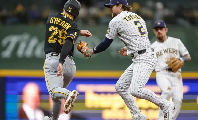 Milwaukee Brewers second baseman Brice Turang (2) tags out Pittsburgh Pirates' Ryan O'Hearn (29) in the base path during the fourth inning of a baseball game Saturday, April 25, 2026, in Milwaukee. (AP Photo/Jeffrey Phelps)