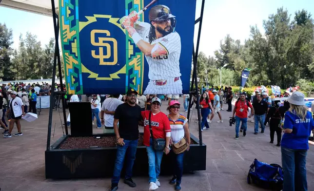 Fans pose with a promotional billboard ahead of the San Diego Padres baseball game against Arizona Diamondbacks in Mexico City, Sunday, April 26, 2026. (AP Photo/Fernando Llano)