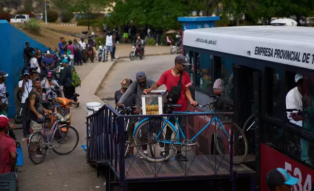 People load their bicycles onto a public bus to cross the Bay Tunnel in Havana, Wednesday, April 8, 2026. (AP Photo/Ramon Espinosa)