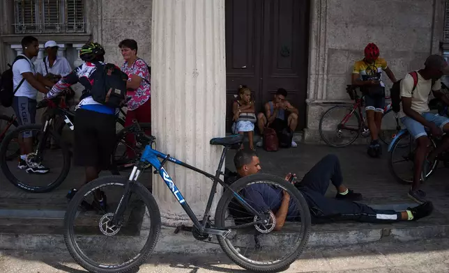 People wait for the arrival of a public bus to transport their bicycles across the Bay Tunnel in Havana, Wednesday, April 8, 2026. (AP Photo/Ramon Espinosa)