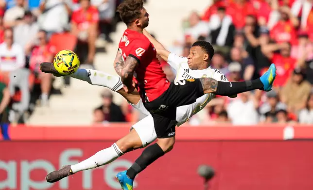 Real Madrid's Kylian Mbappe shoots by Mallorca's Pablo Maffeo during a La Liga soccer match between Mallorca and Real Madrid in Palma de Mallorca, Spain, Saturday, April 4, 2026. (AP Photo/Jose Breton)