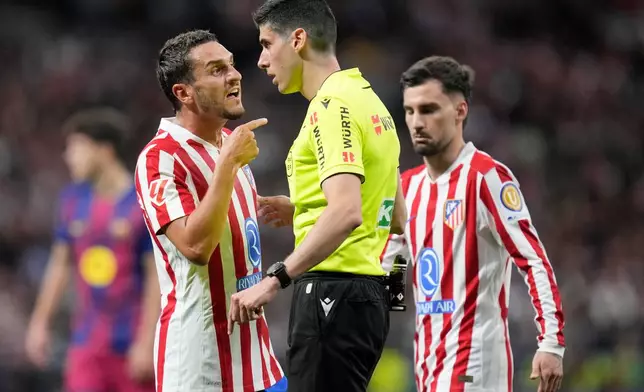 Referee Mateo Busquets speaks to Atletico Madrid's Koke during a La Liga soccer match between Atletico Madrid and Barcelona in Madrid, Spain, Saturday, April 4, 2026. (AP Photo/Bernat Armangue)